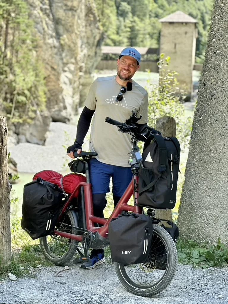 Markus Hilgert mit seinem E-Bike und Packtaschen auf einem Schotterweg